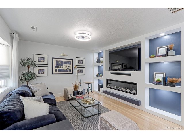 Property Photo 4 This 16x12 living room has beautiful solid Oak floors, designer lighting and a large bay wall of thermal pane windows with custom no cord, light filtering up and down solar shades.