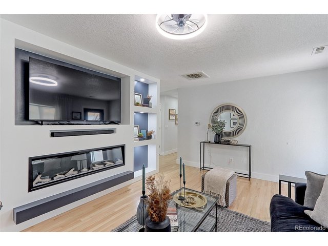 Property Photo 5 Check out the professionally built-in entertainment center with sleek electric fireplace and lighted built-in art nooks and component shelves. This is a perfect spot for your large flat screen TV.