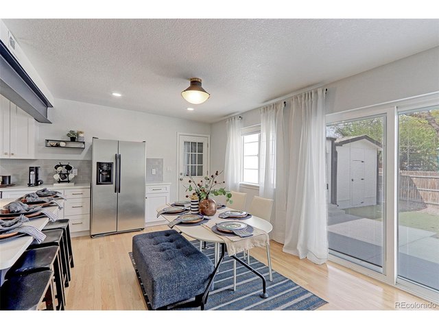 Property Photo 11 There is a newer custom glass sliding door with integrated blinds that will lead you right out to the private backyard from this dining area. The door next to the fridge leads you out to the attached garage.
