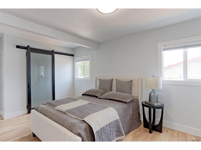 Property Photo 12 This is the large 16x10 primary suite with solid Oak floors, newer thermal pane windows with custom solar shades and newer overhead lighting.