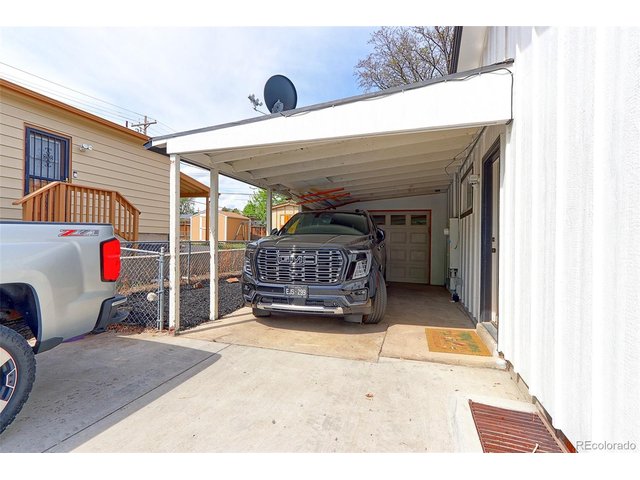 Property Photo 31 This home has an oversized attached garage plus a 21x14 covered carport with tons of off-street parking. The private door entrance to the basement apartment is shown in this photo.